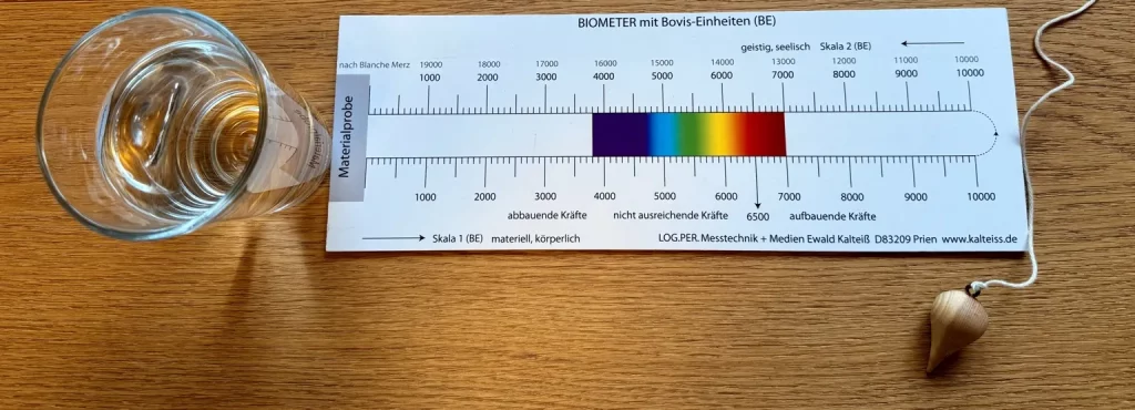 Biometer mit Bovis-Einheiten, hexagonales Wasser im Glas und Pendel zur energetischen Testung der Schwingung.